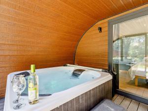 a bath tub with a bottle of wine and a glass at 1 Bed in Okehampton oc-92384 in Okehampton
