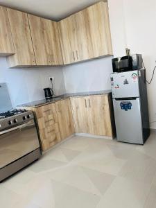 a kitchen with wooden cabinets and a refrigerator at Eunas homestay in Eldoret