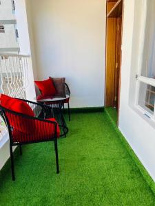 a room with two chairs and a green carpet at Eunas homestay in Eldoret