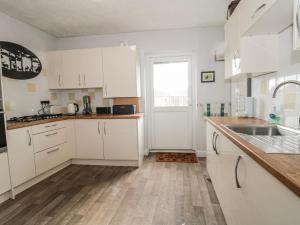 a kitchen with white cabinets and a sink at The Flat House in Taunton