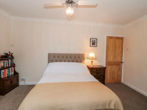 a bedroom with a bed and a dresser with a lamp at The Flat House in Taunton