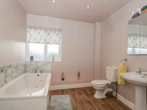 a bathroom with a tub and a toilet and a sink at The Flat House in Taunton +10 photos