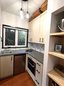 a kitchen with white cabinets and a sink and a window at The Family Cottage in Delta