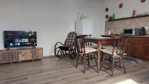 a kitchen with a table and chairs and a tv at Konyhadűlő Vendégház in Kiskunmajsa