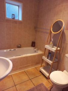 a bathroom with a tub and a toilet and a sink at Forever Clarens in Clarens