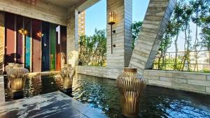 a house with a pool of water with vases in it at 水舞行館-SHUEI WU Boutique Hotel in Taichung