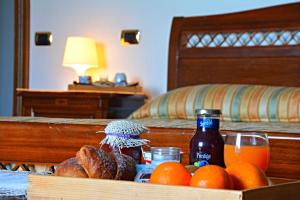 a tray of fruit and a bottle of drink on a bed at Agriturismo il Pettirosso in Pianillo