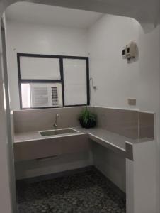 a bathroom with a sink and a window at Tiza Manor Inn in Roxas City +14 photos