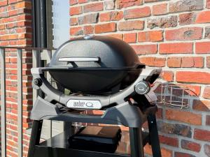 a grill sitting on a table next to a brick wall at Ferienwohnung Sonnenufer am Dümmer See in Lembruch