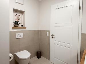 a bathroom with a toilet and a white door at Ferienwohnung Sonnenufer am Dümmer See in Lembruch +15 photos