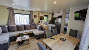 a living room with a couch and a table at Les Prairies de la Mer - Baie de Somme in Favières