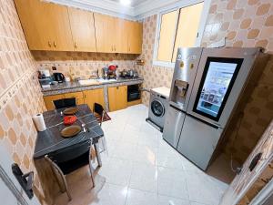a small kitchen with a table and a refrigerator at Itrane Hostel in Tamraght Ouzdar +32 photos