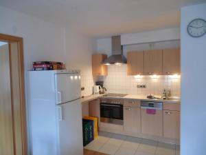 a kitchen with a white refrigerator and a sink at Schmidhauser Hof in Unterwössen