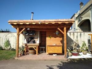 a wooden pergola on the side of a house at L'amandier in Thouars