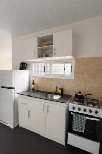 a kitchen with a stove and a sink and a refrigerator at Casa Tetis in La Floresta