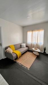 a living room with a couch with a yellow blanket at Casa Tetis in La Floresta