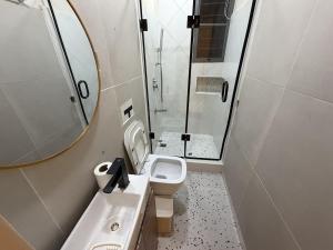 a bathroom with a sink and a toilet and a mirror at Caramel Cove Lekki in Mama