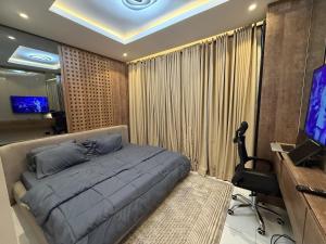 a bedroom with a large bed and a television at Caramel Cove Lekki in Mama