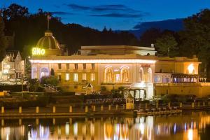 a building lit up at night next to a body of water at Villa Millepertuis Bagnoles de l'Orne in Bagnoles de l'Orne