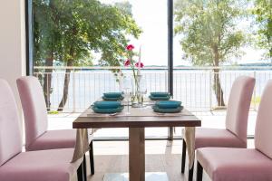 a table with chairs and a vase of flowers on it at Blue & Green Masurian Hotel in Węgorzewo
