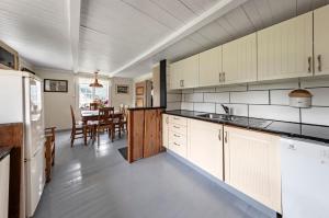 a kitchen with white cabinets and a dining room at Staurset gård in Mittet