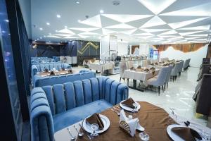 a dining room with blue chairs and tables and tablesearcher at Hotel Crown Park Ltd in Sylhet