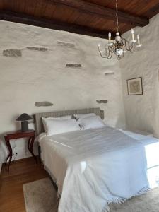 a bedroom with a white bed and a chandelier at Old town gem in Tallinn