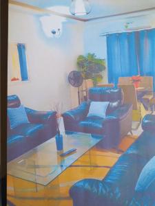 a living room with blue couches and a glass table at Appartement bonita in Dakar