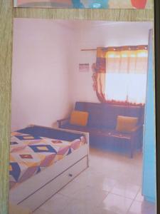 a small bedroom with a bed and a window at Appartement bonita in Dakar