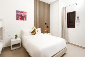 a white bedroom with a large white bed in it at Hotel H4 El Paraíso in El Paraíso