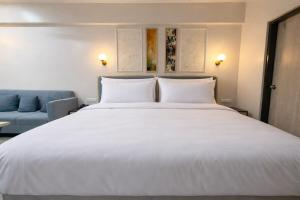 a bedroom with a large white bed and a blue couch at Morden luxury studio in Jaipur