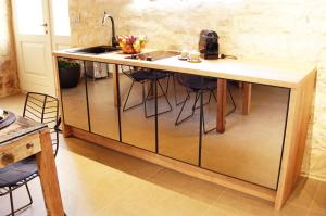 an island in a kitchen with a sink and stools at History Hvar 1529 in Hvar