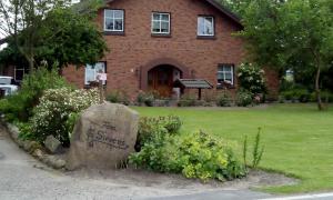 una casa de ladrillo con una piedra delante de un patio en Ferienwohnung Sievers, en Barlt
