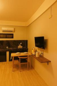 a living room with a table and a television at Perrera Guesthouse in Santa Ana