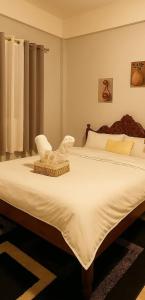 a bedroom with a large bed with a chair on it at Perrera Guesthouse in Santa Ana