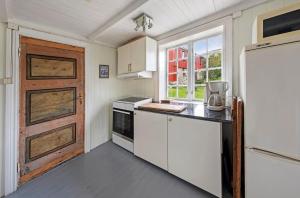 a kitchen with white cabinets and a refrigerator at Staurset gård in Mittet +31 photos