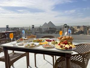 a table with plates of food on top of a balcony at NEW ASSER HOTEL PYRAMID in Cairo