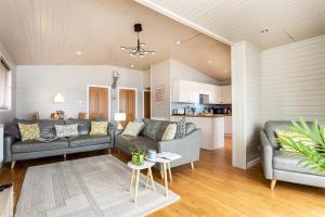 a living room with two couches and a table at Keer Lodge a lakeshore haven Pine Lake Resort in Carnforth