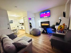 a living room with a couch and a flat screen tv at Downtown Home - Close to Topgolf, Ravens Stadium, Orioles Park, UM Baltimore in Baltimore