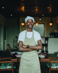 a man in a chefs hat standing with his arms crossed at Tano Bora Hotel in Sekenani