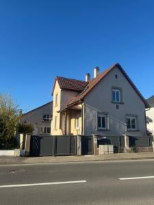 a white house on the side of a street at Le gîte de L Échappée Alsacienne in Geispolsheim