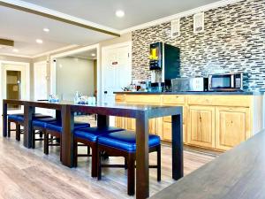 a kitchen with a long table and blue chairs at Americas Best Value Inn Suites & Studios Blytheville by Sonesta in Blytheville