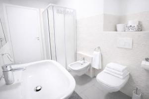 a white bathroom with a toilet and a sink at Bella Vita Stays Happy in Sondrio +8 photos