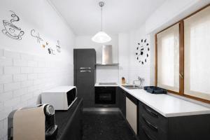 a kitchen with a black refrigerator and a microwave at Bella Vita Stays Happy in Sondrio