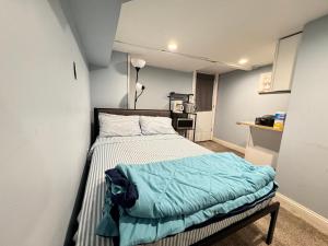 a small bedroom with a bed with a blue blanket at Downtown Suite - Close to Topgolf, Horseshoe Casino, UM Baltimore in Baltimore