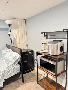 a room with a microwave on a shelf next to a bed at Downtown Suite - Close to Topgolf, Horseshoe Casino, UM Baltimore in Baltimore