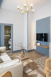 a living room with a white couch and a tv at Apartamentos 4Duques in Cáceres