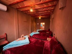 a row of three beds in a room at La Baraka Auberge in Aït Benhaddou
