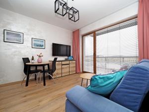 a living room with a blue couch and a table at Apartament KLARA in Sarbinowo