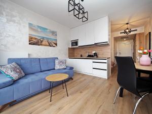 a living room with a blue couch and a table at Apartament KLARA in Sarbinowo